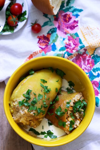 Poivrons farcis servis avec de la crème sure et du pain, un plat traditionnel de différentes nations.