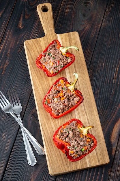 Poivrons farcis à la viande hachée sur la planche de bois