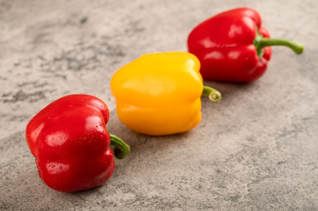 Poivrons frais colorés placés sur la surface de la pierre