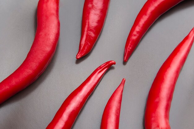 Poivrons frais rouges épicés sur un gros plan gris