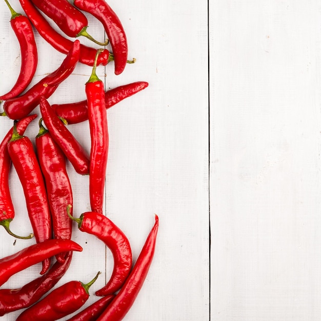 Poivrons pepperoni rouges sur une table en bois blanche