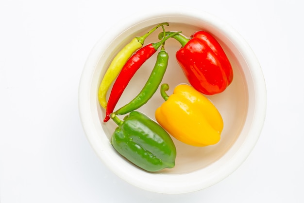 Poivrons et piments de différentes couleurs trempés dans de l&#39;eau.