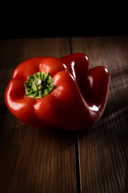 Poivrons rouges allumés sur une table en bois.