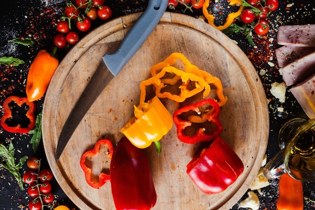 Poivrons rouges doux sur une planche à découper. Ingrédients frais de la salade. Concept de mode de vie sain