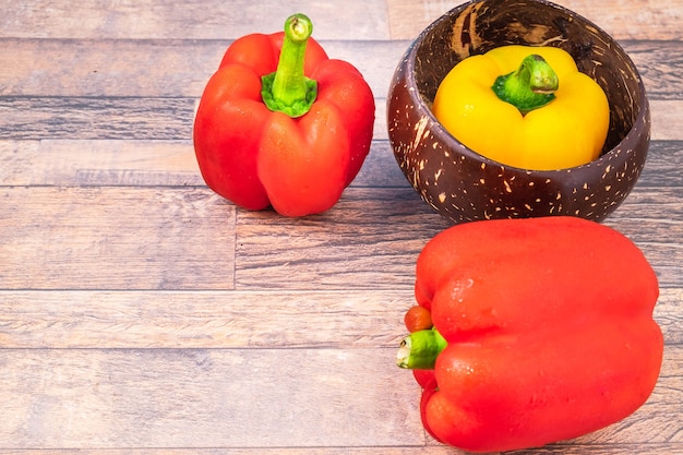 Poivrons rouges et jaunes sur fond de bois.