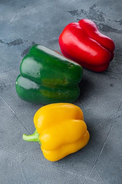 Poivrons rouges et jaunes verts colorés sur le fond gris