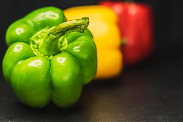 Photo poivrons rouges orange jaune poivrons verts sur fond sombre