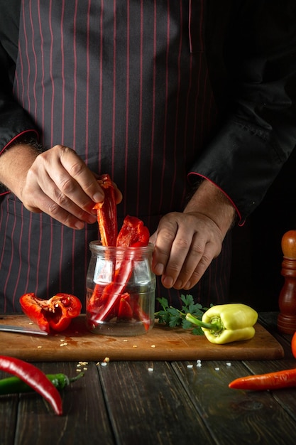 Photo des poivrons rouges sucrés tranchés sur une planche à couper en bois par un chef professionnel.