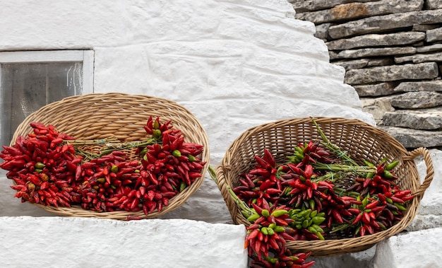 Poivrons séchés dans des paniers sur un mur à Ostuni