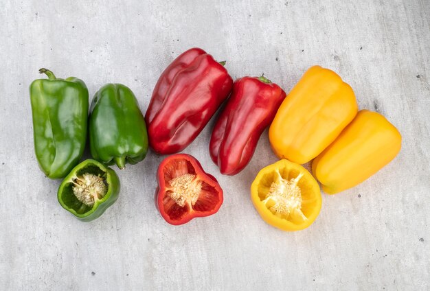 Poivrons verts rouges et jaunes sur fond rustique