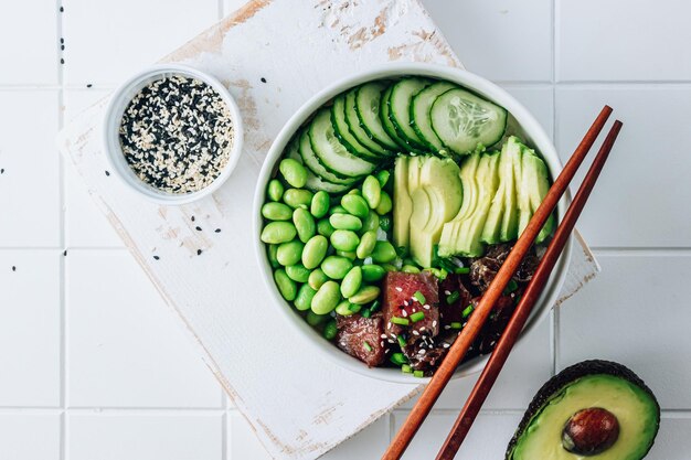 Poke bol avec du riz au thon cru, des haricots edamame à l'avocat et du concombre dans un bol Hawaiian ahi poke bowl