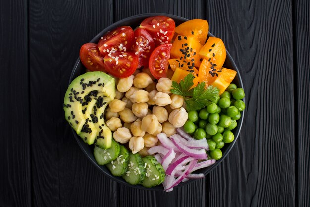 Poke bowl vegan avec pois chiches et légumes dans le bol noir