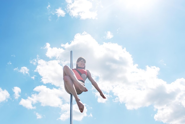 Pole dance fit woman exerçant avec pylône à l'extérieur