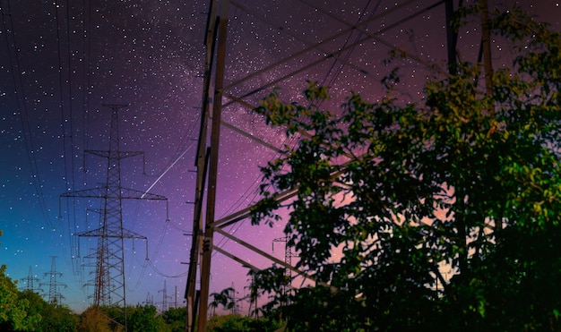 Pôle haute tension avec voie lactée dans le ciel. vue industrielle des lignes à haute tension.