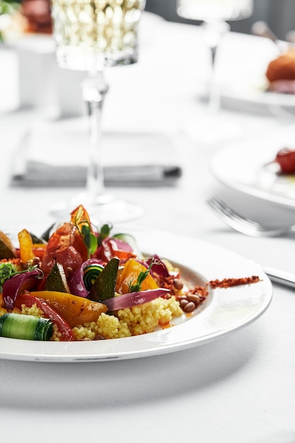 Photo polenta avec gros plan de légumes, un plat de farine de maïs avec des légumes sur une plaque blanche, fond clair.