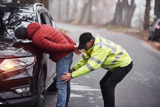 Un policier en uniforme vert a attrapé un vol d'automobile sur la route.