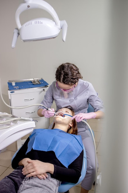 Polissage des dents Services dentaires Dentiste faisant le nettoyage professionnel des dents jeune patiente au cabinet dentaire plan Gros plan