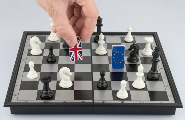 La politique de la main soulève la figure avec le drapeau de la Grande-Bretagne Le concept de jeu politique et de stratégie