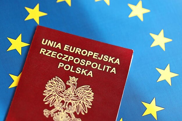 Photo pologne passeport de l'union européenne sur fond de drapeau bleu en gros plan concept de tourisme et de citoyenneté