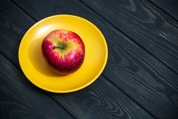 Une pomme sur une assiette orange