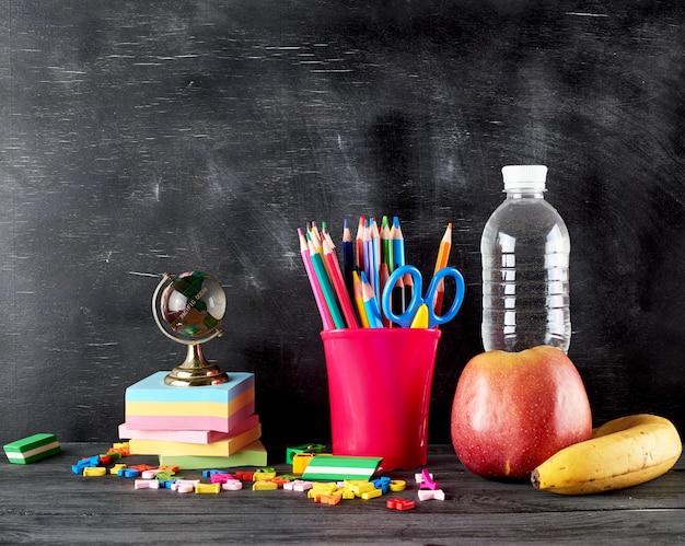 Pomme, banane, bouteille d'eau et papeterie pour l'école