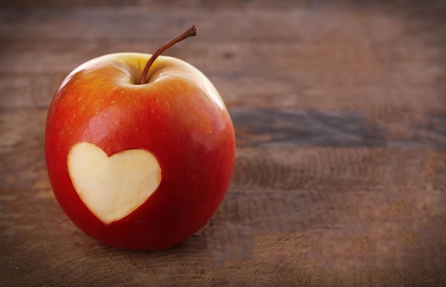 Pomme avec coeur sur table en bois