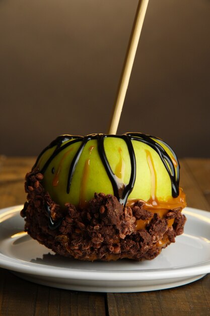 Pomme confite sur bâton sur table en bois