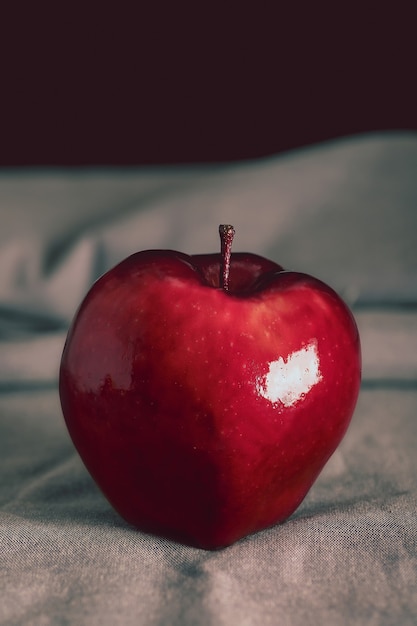 Pomme délicieuse rouge sur une nappe grise