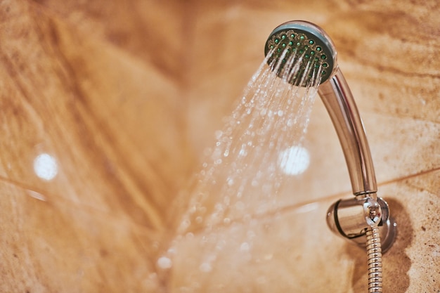 Pomme de douche dans la salle de bain avec eau