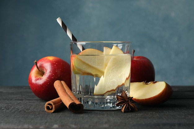 Pomme, eau et cannelle sur bois, gros plan