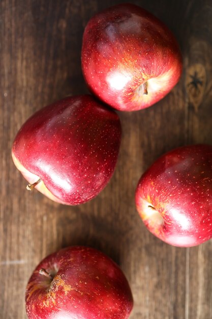 Pomme fraîche rouge sur une table de cuisine texturée en bois