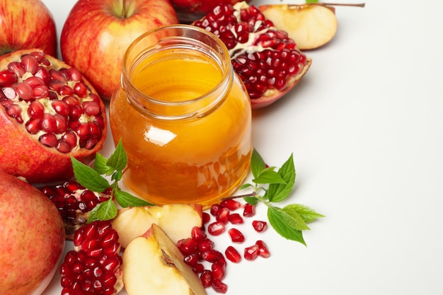 Pomme, grenade et miel sur blanc, gros plan. Traitement à domicile