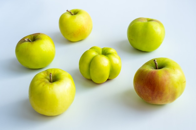 La pomme intéressante, inhabituelle et étrange. Une pomme laide entourée de pommes ordinaires. La photo symbolise l'individualité, le leadership, les caractéristiques personnelles, l'acceptation de soi.