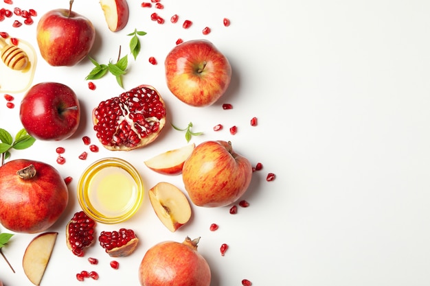 Pomme, miel et grenade sur blanc, vue du dessus