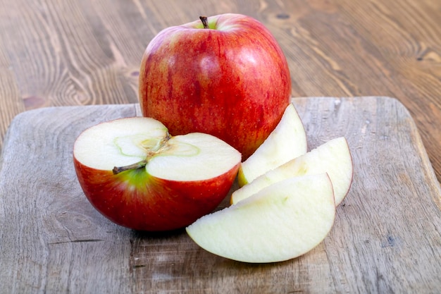 Pomme mûre rouge sur une planche à découper en bois