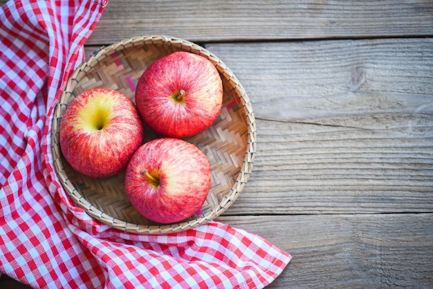 Pomme sur panier sur la table en bois pommes rouges mûres vue de dessus