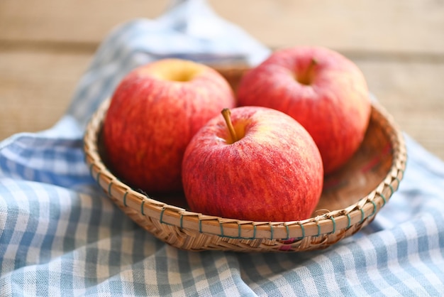 Pomme sur panier sur la table en bois pommes rouges mûres