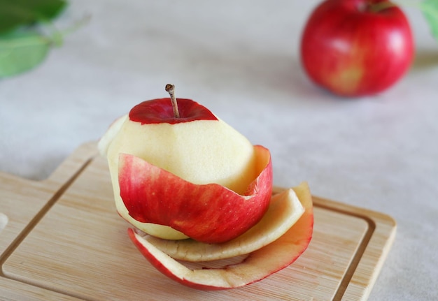 Une pomme pelée se trouve sur une planche de bois Concept zéro déchet