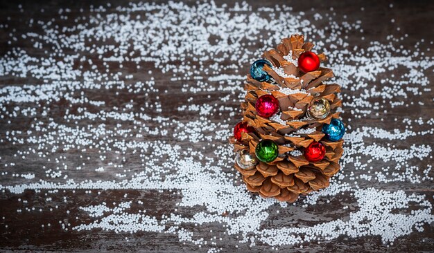 Pomme de pin décorée d'ornements de Noël