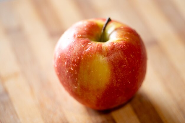 Photo pomme rouge allongée sur la table au soleil en gros plan nourriture fruits vitamines concepts nutritionnels