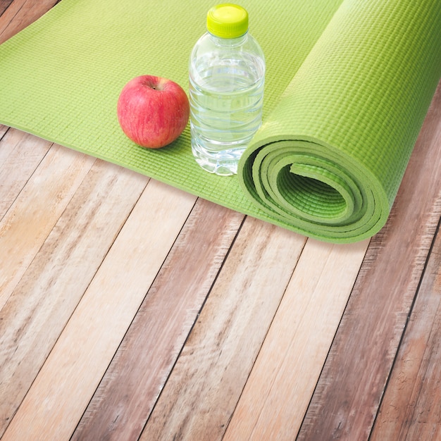 Pomme rouge, bouteille d&#39;eau et tapis de yoga