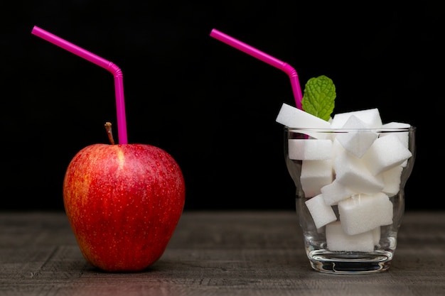 Pomme rouge et cocktail avec des cubes de sucre, choix de consommation de sucre