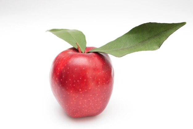 Photo pomme rouge avec des feuilles vertes sur fond blanc