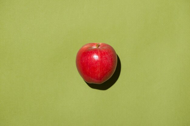 La pomme rouge sur fond vert.