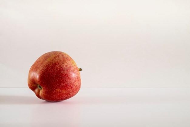 Une pomme rouge fraîche sur fond blanc