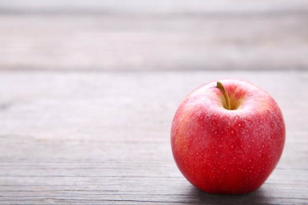 Pomme rouge fraîche sur un fond en bois gris