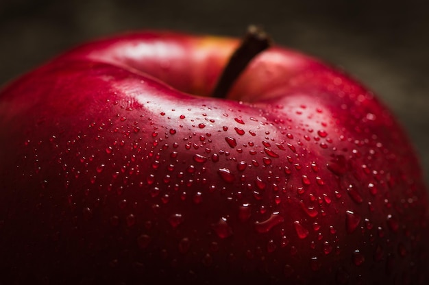 Pomme rouge gros plan Pomme rouge fraîche sur une texture de fond noir