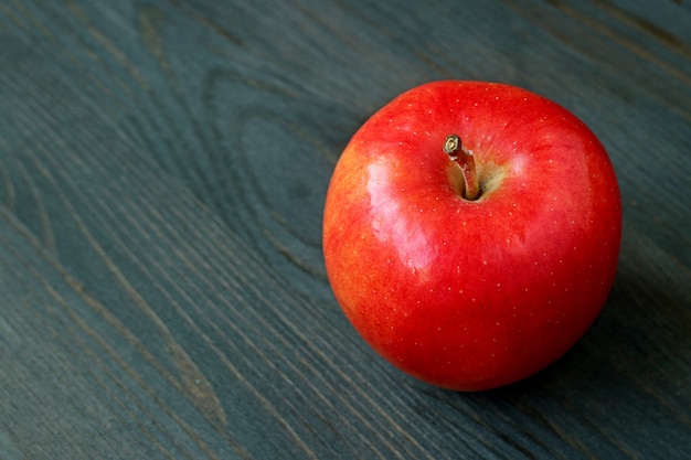 Pomme rouge isolé sur une table en bois de couleur foncée avec espace copie