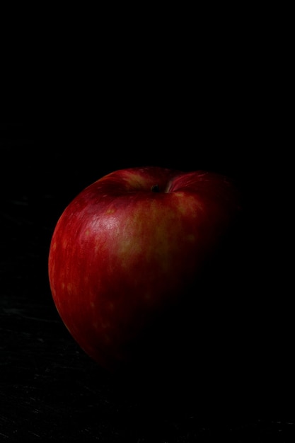 Pomme rouge isolée sur le fond en bois noir
