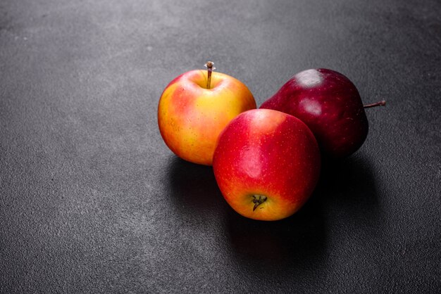 Pomme rouge juteuse fraîche avec des gouttelettes d'eau contre une surface sombre